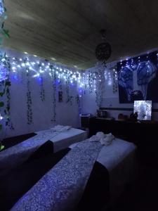 a room with three beds with lights on the wall at Casa Ticitl temazcalli in Tepoztlán