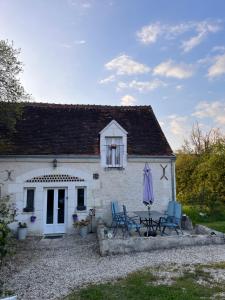 a white cottage with two chairs and an umbrella at Bblodges Loches Beauval in Saint-Hippolyte
