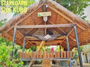 a large bamboo hut with a hammock in it at Ālon in Linukso