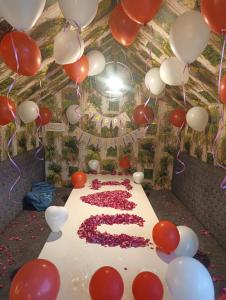 a birthday cake with red and white balloons at Mitanvi the heaven in Ujjain