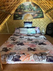 a bed with a comforter on it in a room at Ālon in Linukso