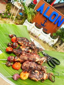 a plate of food on top of a banana leaf at Ālon in Linukso