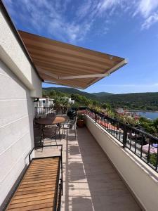 a patio with a table and chairs on a balcony at SUNTIME apartament 5 in Kotor