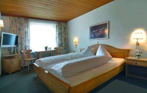 a bedroom with a large bed and a television at Gasthof Bad Sonnenberg in Nüziders