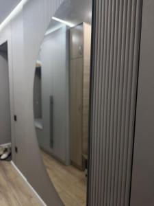 a mirror reflection of a hallway with a bathroom at Квартира на Толе би in Taraz