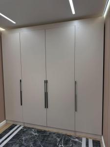 a closet with white cabinets in a room at Квартира на Толе би in Taraz