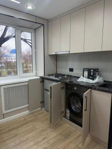 a kitchen with a washer and dryer in it at Квартира на Толе би in Taraz
