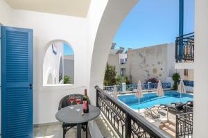 a balcony with a table and chairs and a swimming pool at Naxos Diol in Naxos Chora