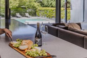 a table with a plate of food and a bottle of wine at Thule Country Estate - Private Architect-Designed Farm Estate, 6 Bedrooms, Sleeps 12 in Mount Macedon