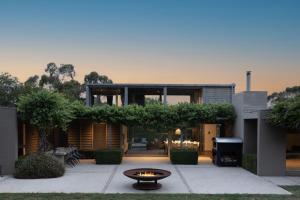 a house with a fire fountain in front of it at Thule Country Estate - Private Architect-Designed Farm Estate, 6 Bedrooms, Sleeps 12 in Mount Macedon