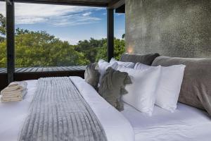 a white bed with white pillows and a window at Thule Country Estate - Private Architect-Designed Farm Estate, 6 Bedrooms, Sleeps 12 in Mount Macedon