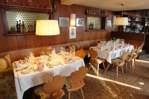 a dining room with white tables and chairs and lights at Gasthof Bad Sonnenberg in Nüziders