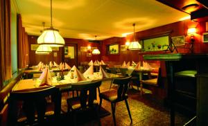 a dining room with many tables and chairs and lights at Gasthof Bad Sonnenberg in Nüziders