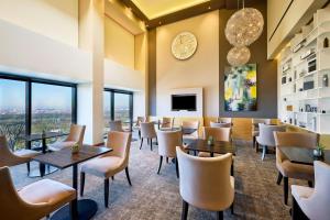 a restaurant with tables and chairs and windows at The Westin Grand Munich in Munich