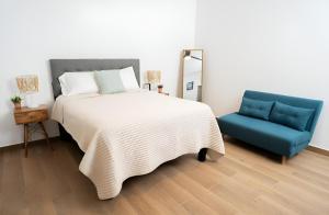 a bedroom with a bed and a blue chair at Casa Puerto Azul in San Carlos +8 photos