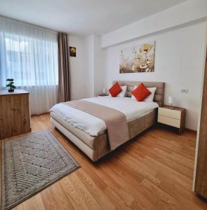 a bedroom with a large bed with red pillows at Rin Elegance Apartament in Bucharest +32 photos