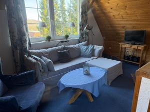 a living room with a couch and a table at Landhotel Villa Foresta Braunlage in Braunlage