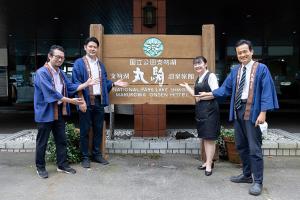 a group of people standing in front of a sign at Sapporo's Secret Onsen Sanctuary Marukoma Onsen Ryokan in Chitose +55 photos