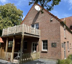 a brick house with a wooden deck on the side of it at Ferienhaus Heidefee in Wietzendorf