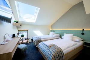 two beds in a room with a skylight at Hotel Roudna in Pilsen +89 photos