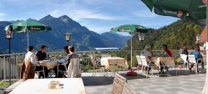 a group of people sitting at tables on a balcony at Gasthof Bad Sonnenberg in Nüziders