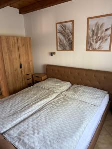 a bed in a bedroom with two pictures on the wall at R-Home Apartman in Zamárdi