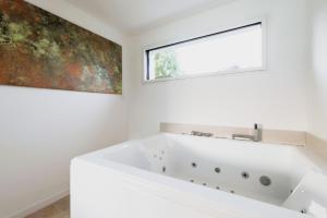 a bath tub in a bathroom with a window at Les Joyaux d'Eliane in Le Bernard
