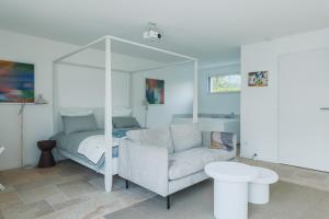 a living room with a couch and a bed at Les Joyaux d'Eliane in Le Bernard