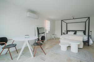 a bedroom with a bed and a table and chairs at Les Joyaux d'Eliane in Le Bernard