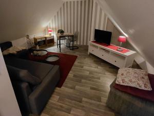 a living room with a couch and a television at Apartment in Stedesdorf +3 photos