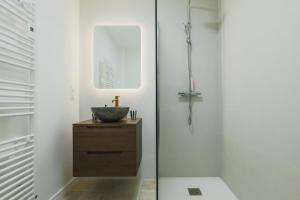 a bathroom with a sink and a glass shower at Les Joyaux d'Eliane in Le Bernard +2 photos