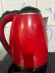a red tea pot sitting on a table at Raibas Homestay in Darjeeling