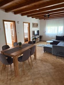 a living room with a wooden table and chairs at R-Home Apartman in Zamárdi
