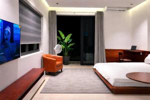 a bedroom with a bed and a tv and a desk at NOAM Stay - Sea Corner in Danang