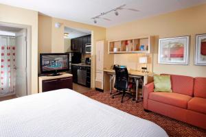 a hotel room with a bed and a couch and a desk at TownePlace Suites by Marriott Sudbury in Sudbury