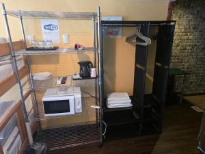 a small room with a microwave on a shelf at Sophiearth Apartment in Tokyo