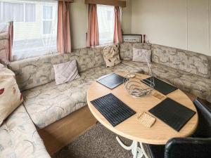 a living room with a table and a couch at Joys in Jaywick Sands