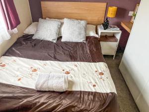 a bed with two pillows on it in a bedroom at Joys in Jaywick Sands