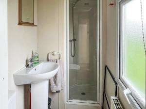 a bathroom with a sink and a shower at Joys in Jaywick Sands +1 photo