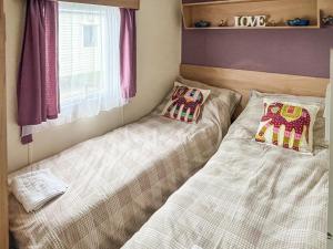 two beds sitting next to each other in a room at Joys in Jaywick Sands