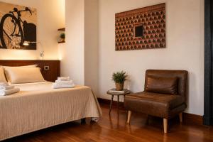 a hotel room with a bed and a chair at Boutique Rooms 3 0 in Ferrara