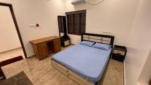 a bedroom with a bed and a wooden cabinet at Souparnika apartments in Varkala