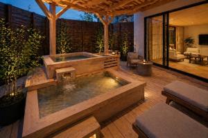 a hot tub on a wooden deck with a patio at 카미소 in Tsushima +70 photos