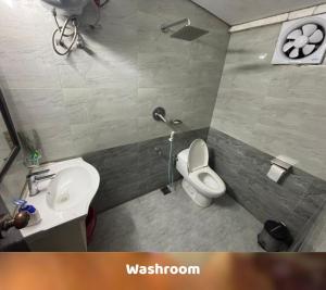 a bathroom with a white toilet and a sink at Sampan Cafe and Resort in Cox's Bazar