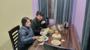 a man and woman sitting at a table eating food at Tungnath View Homestay in Sari +37 photos