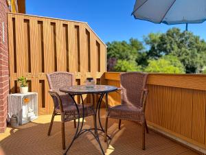 a table and chairs on a balcony with an umbrella at Sonnenhof Damnatz -Hotel garni- in Damnatz