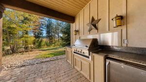 an outdoor kitchen with a stove and a patio at BOTHR Steelhead in McCall +27 photos
