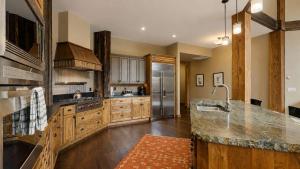a large kitchen with wooden cabinets and a stainless steel refrigerator at BOTHR Steelhead in McCall
