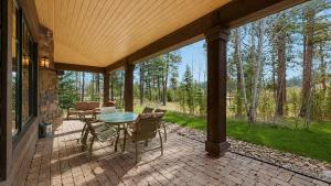 a screened porch with a table and chairs on it at BOTHR Steelhead in McCall