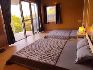 a bedroom with two beds and a large window at La An Homestay in Vĩnh Hy +19 photos